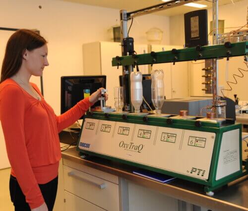 Woman in front of another bottle testing machine